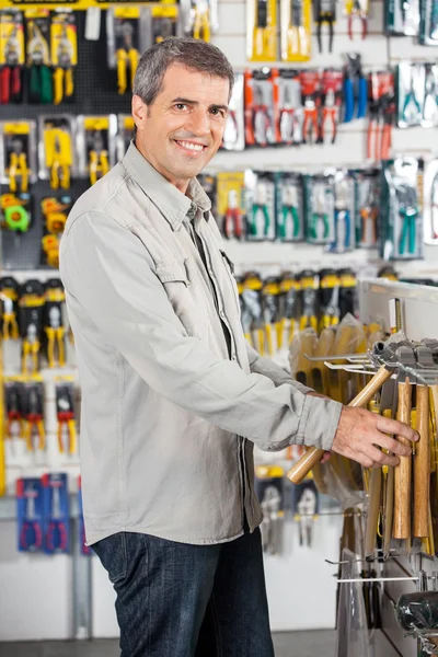 Man Buying Hammer In Hardware Store