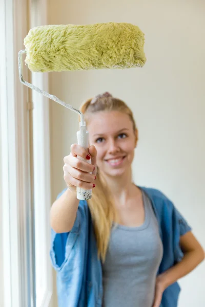 Young beautiful woman painting hew new home.
