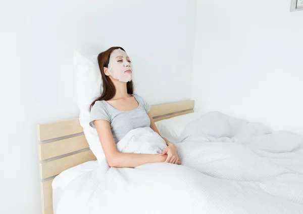Woman using paper mask on face