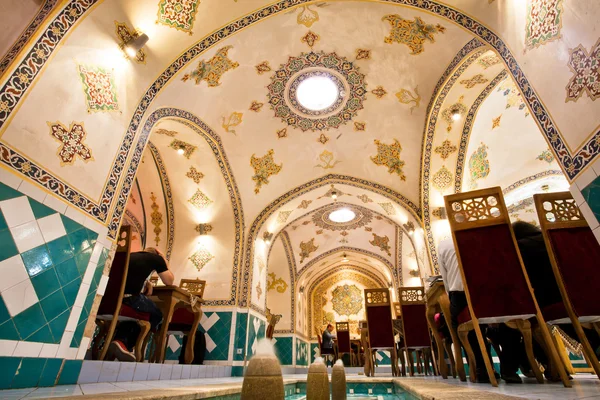 Ceiling and patterned walls inside the persian restaurant with eating people inside