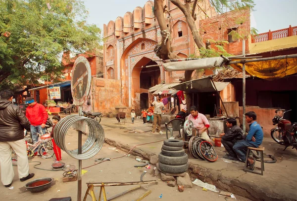 Technician workers repairing wheels for cars and bicycles in a street shop of indian city
