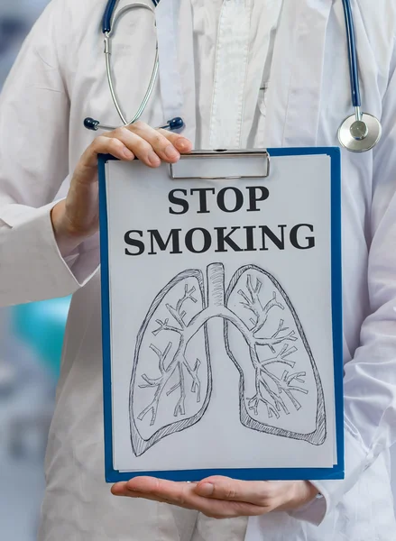 Doctor holds clipboard with lungs and stop smoking label