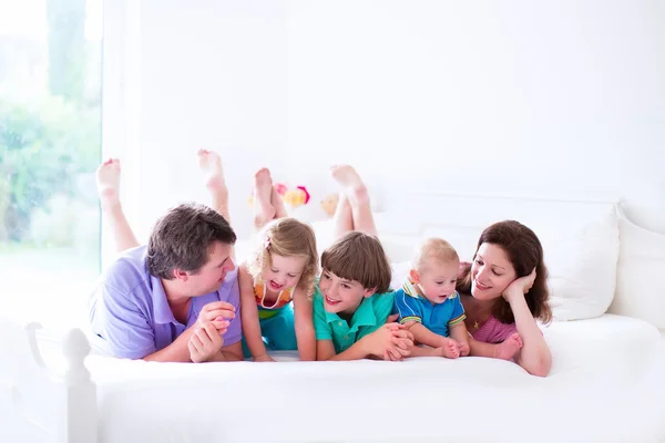 Family with three kids in bedroom