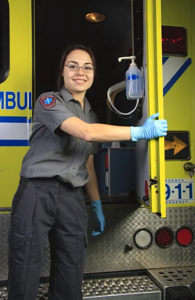 A paramedic, closing the door of the ambulance.