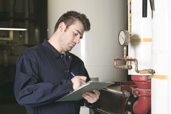 Maintenance engineer checking technical data of heating system e
