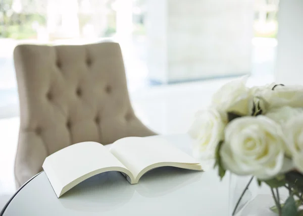 Book on table with white rose flower