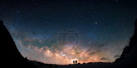 couple standing together against the milky way galaxy